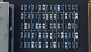 Vue aérienne d'un parc de véhicules d'occasion alignés sur un parking professionnel